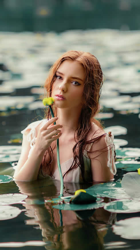 池塘中拿花的金发美女高清壁纸图片 2160x3840