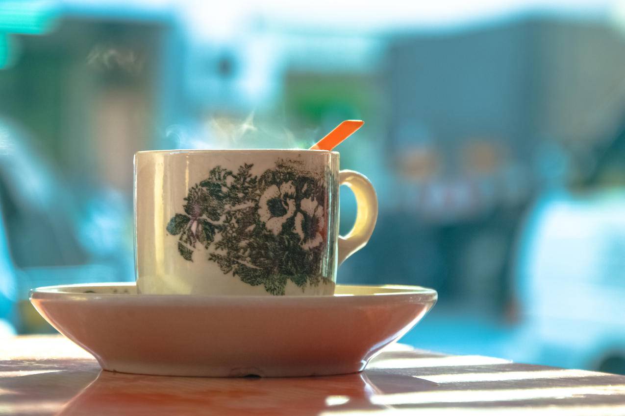白色陶瓷板上的白色和绿色陶瓷杯