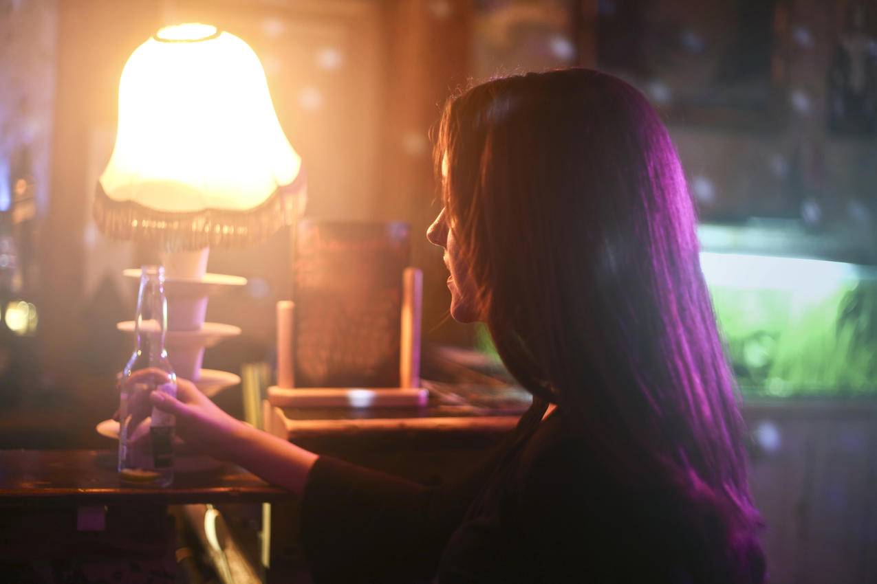 一个拿啤酒瓶的女人的图片
