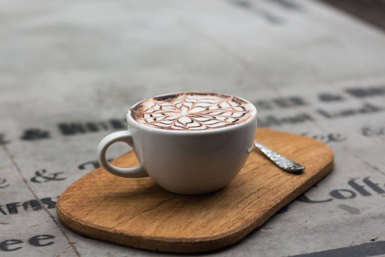 茶杯旁茶杯中的卡布奇诺