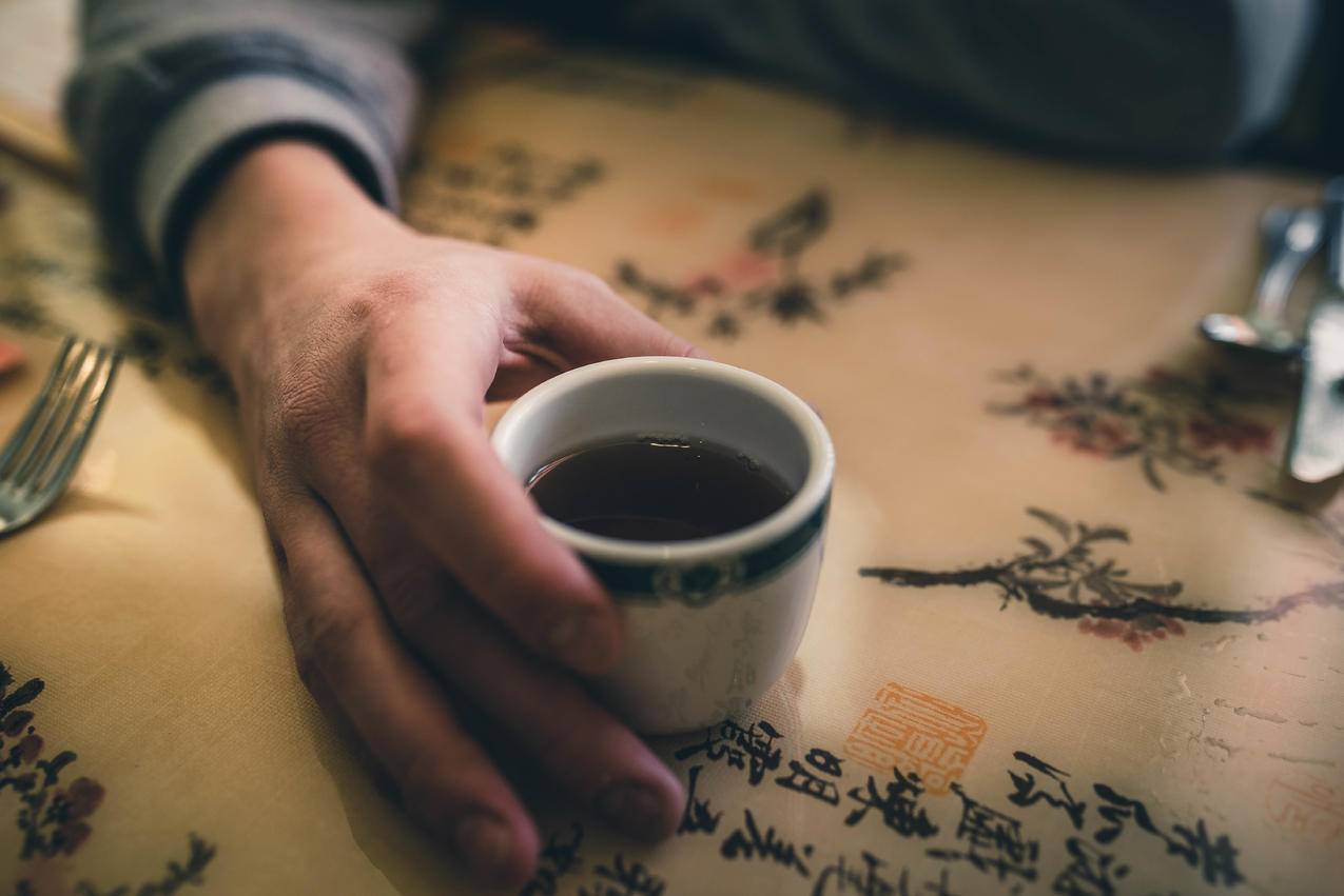 怀抱白陶瓷杯的人