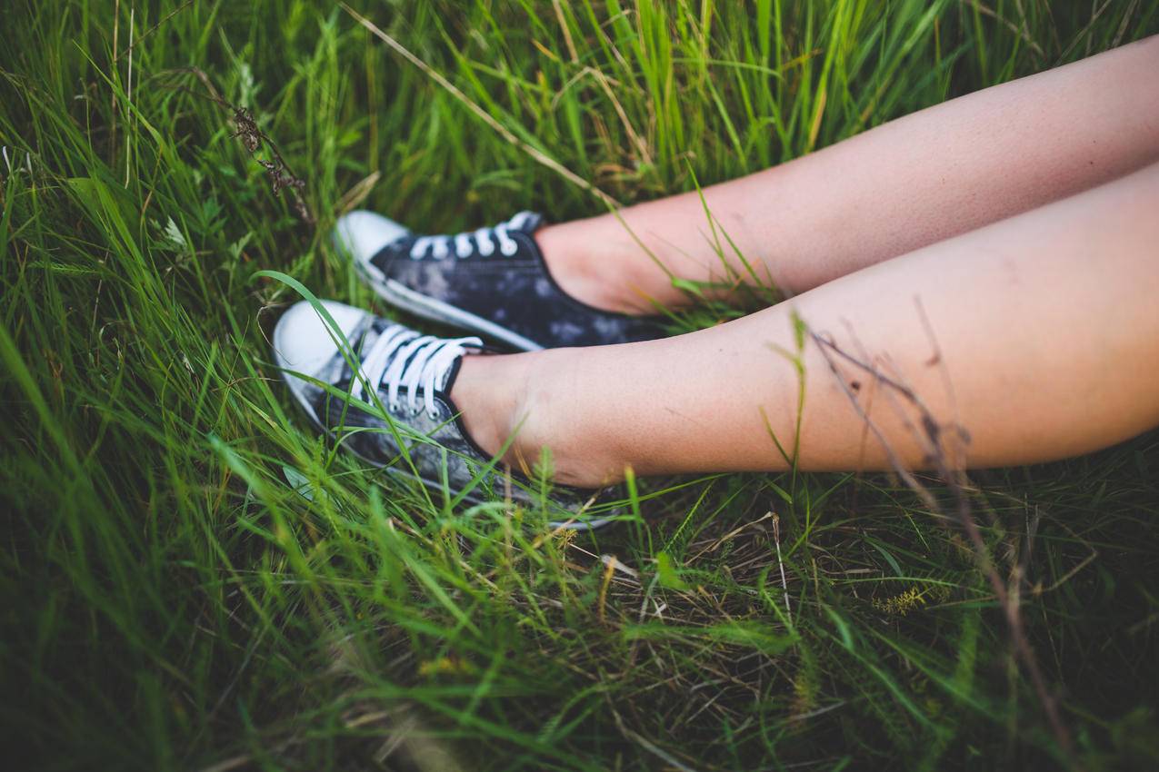 草地上女孩腿上的运动鞋