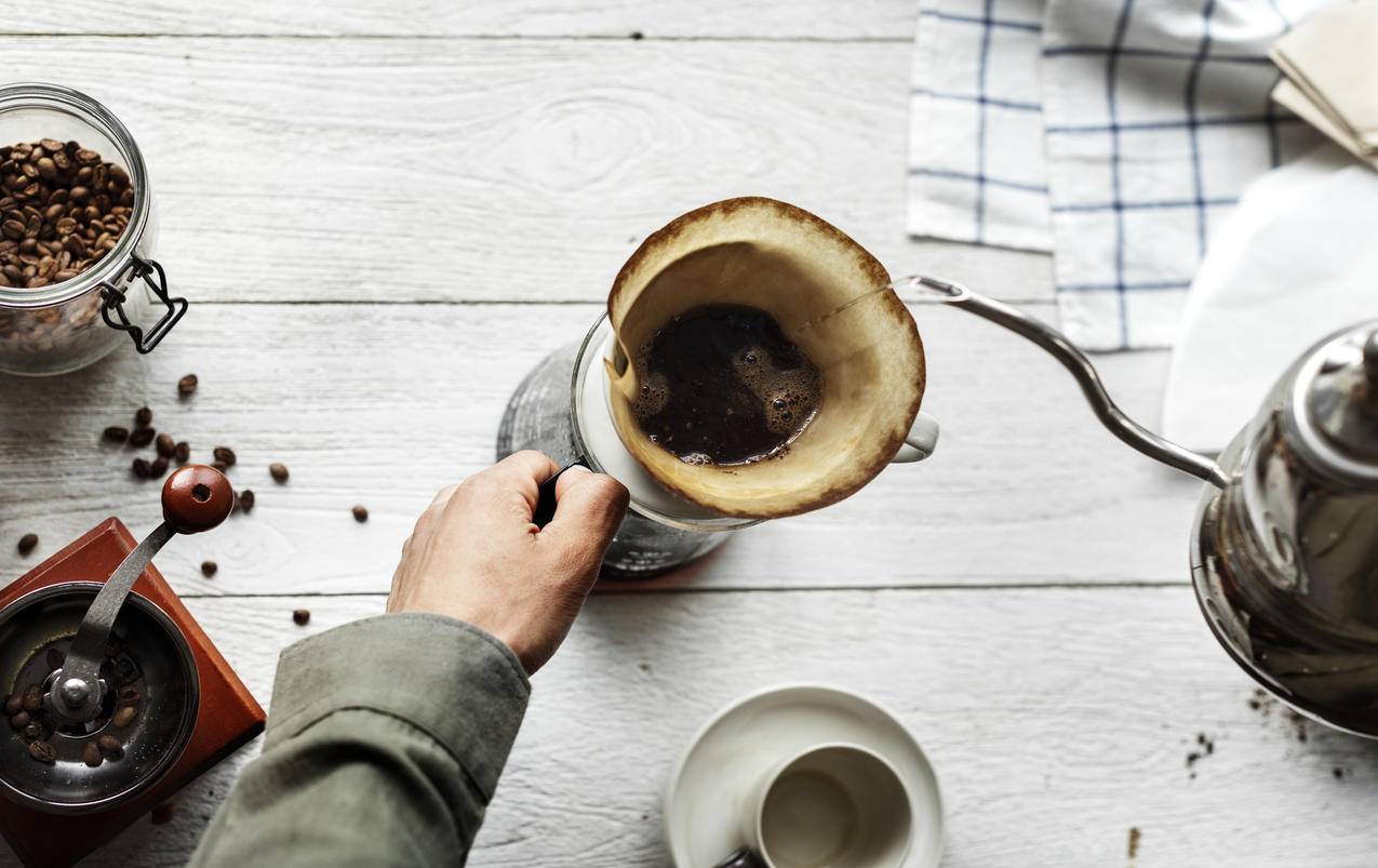 怀抱白陶瓷茶杯的人