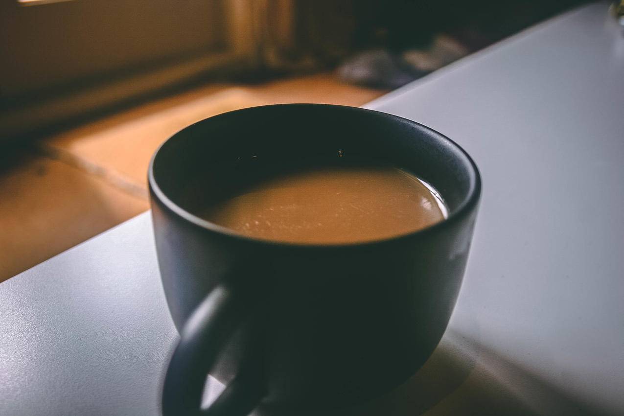 浅棕色陶瓷杯上的棕色咖啡杯