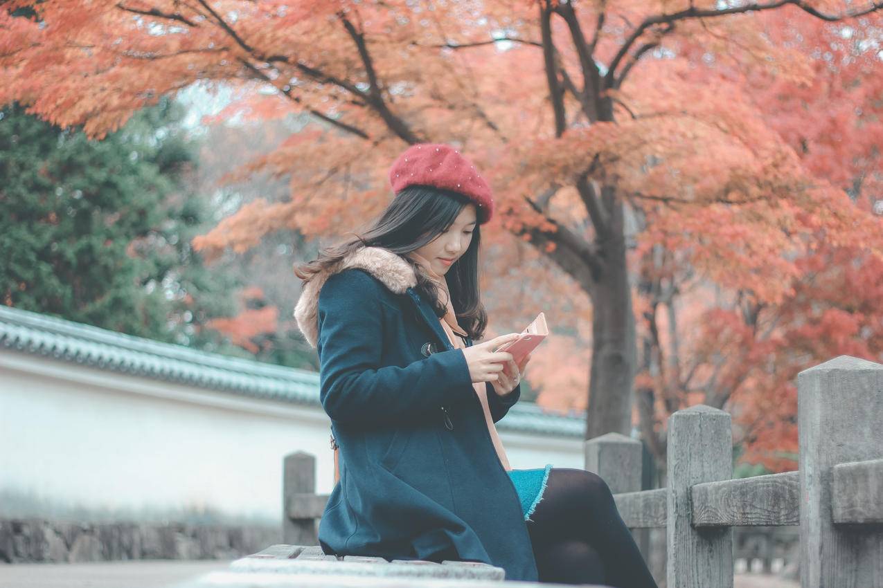 穿着蓝色混凝土长凳的妇女坐在灰色的混凝土长凳上看书