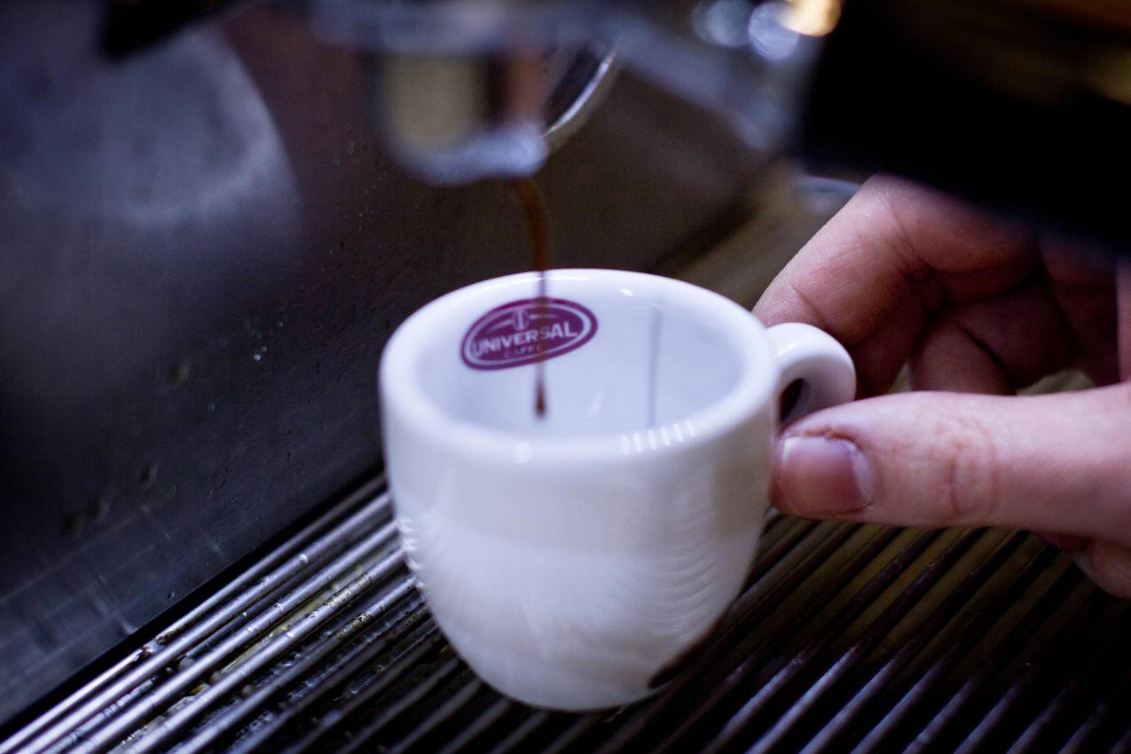 怀抱白陶瓷茶杯的人
