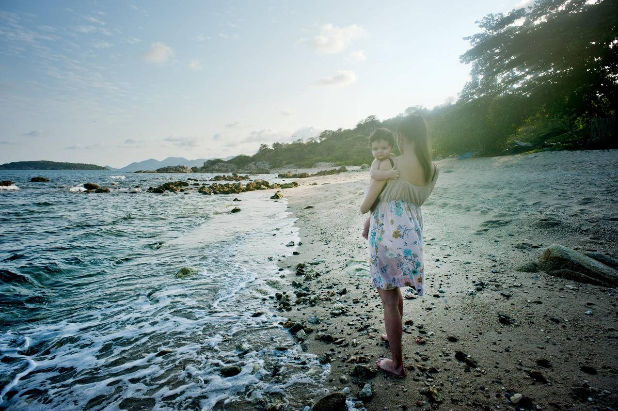 海边抱着婴儿的女人