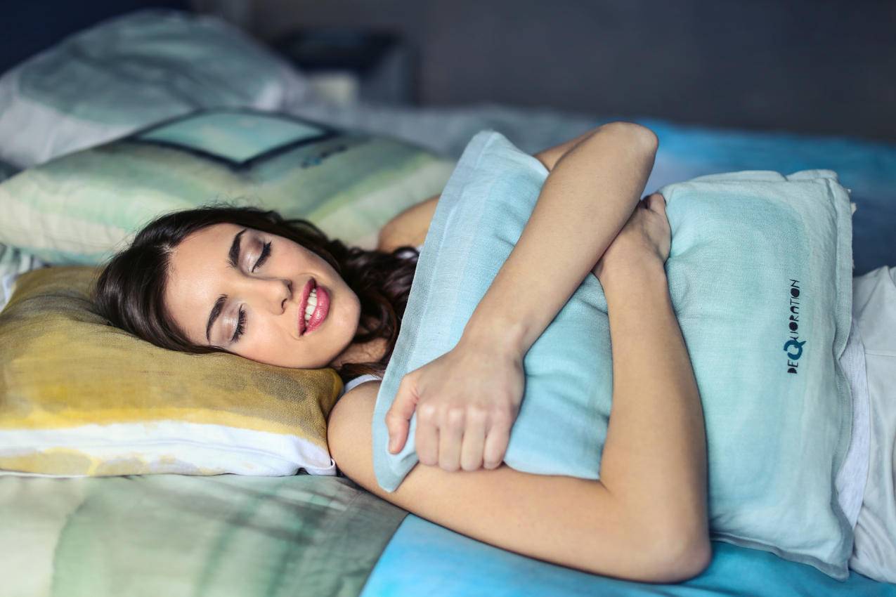 一个抱着蓝色枕头的女人的高清图片