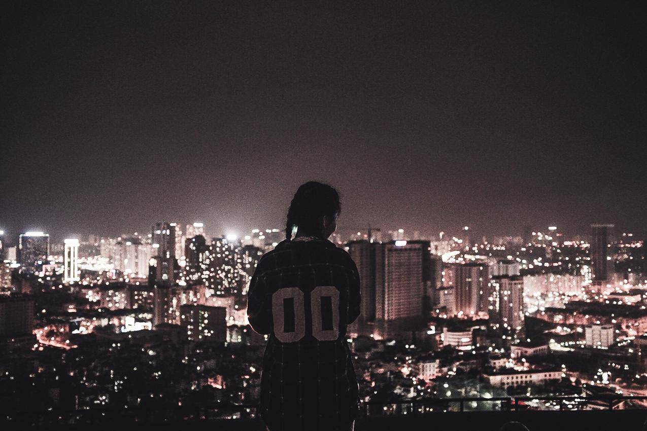 一个晚上看城市灯光的人的高清大图